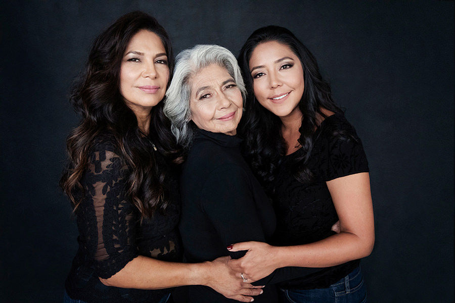 Women from three generations hugging each other.